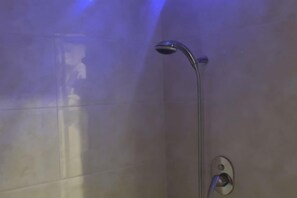 A shower with a handheld showerhead mounted on a wall. - K GARDEN HOTEL PARIT BUNTAR (Parit Buntar)