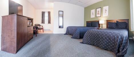 A bedroom with two beds, a dresser, a chair, a desk, and a mirror.