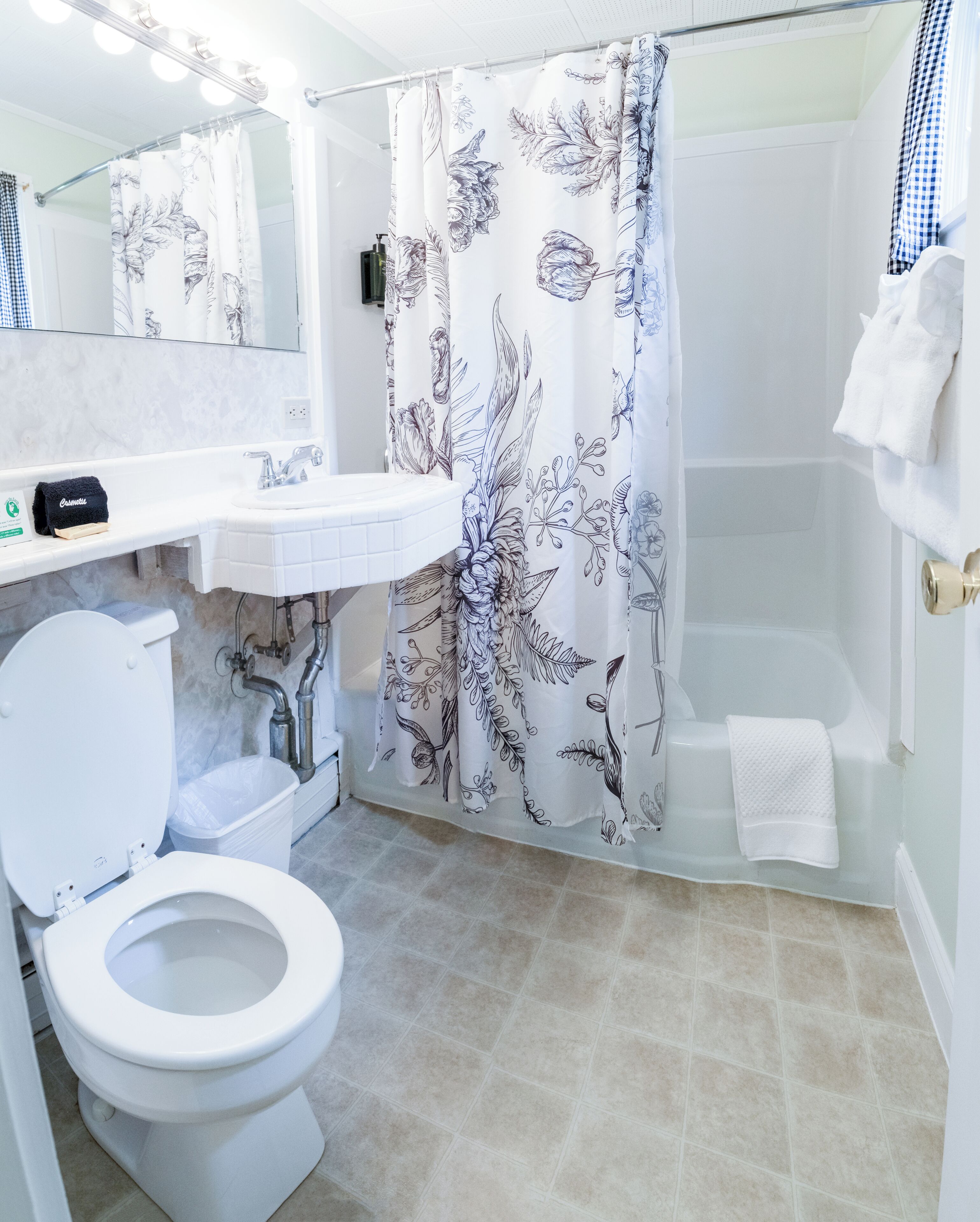 A bathroom with a toilet, sink, and shower area.