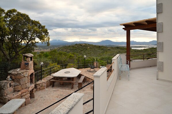 A terrace with stone benches, a table, and a pergola overlooking a mountainous landscape with a view of a body of water. - Bougainvillier
Villa in Pedra Longa. Panoramic view, private pool. (Porto Istana)