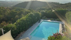 A swimming pool surrounded by lush greenery and a view of distant mountains. - Bougainvillier
Villa in Pedra Longa. Panoramic view, private pool. (Porto Istana)
