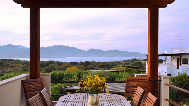 A wooden pergola with a table and chairs, overlooking a scenic landscape with mountains and a body of water. - Bougainvillier
Villa in Pedra Longa. Panoramic view, private pool. (Porto Istana)