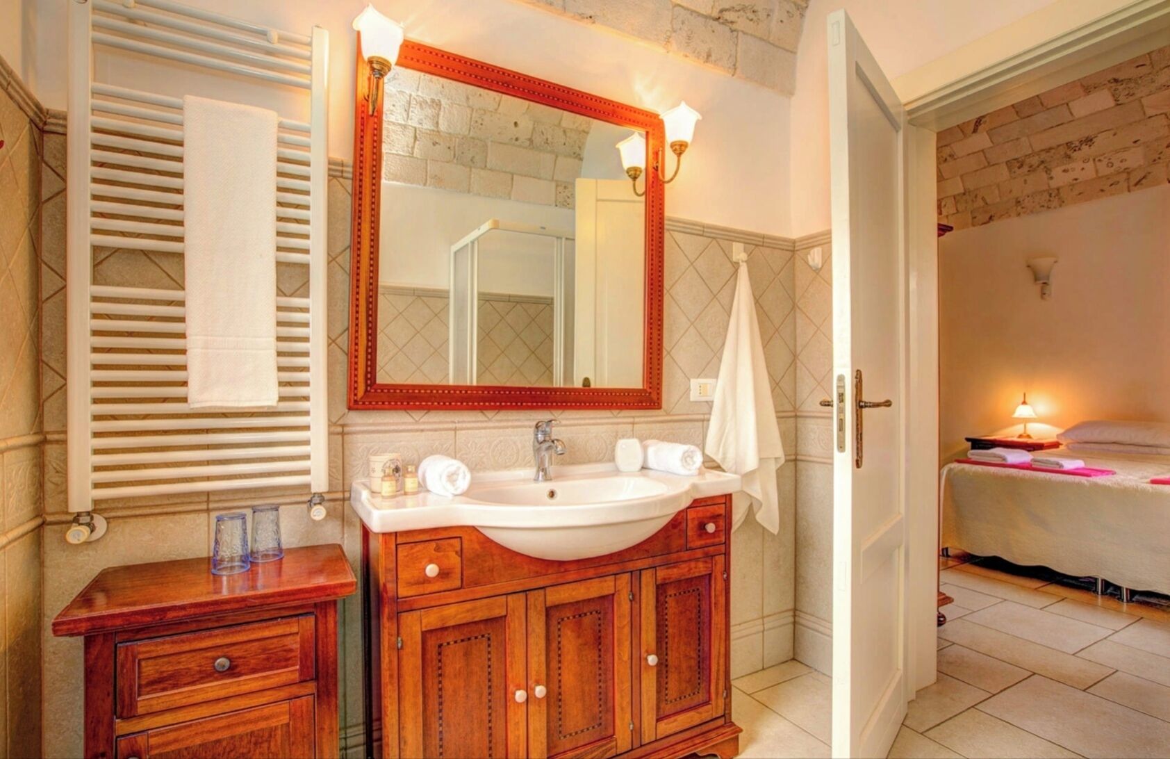 A bathroom with a wooden vanity, a large mirror, and a white sink.