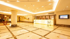 A spacious lobby with a marble floor, a reception desk, and a television screen. - Argyle International Airport (Shanghai)