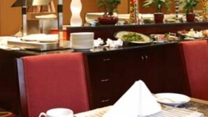 A hotel dining area with a buffet setup, including a variety of dishes and a coffee station. - Argyle International Airport (Shanghai)