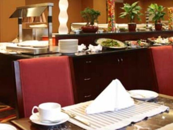 Een restaurantgedeelte in een hotel, met een buffet en een koffiehoek.