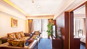 A hotel room with a sofa set, a flat-screen TV, a coffee table, and a large window with curtains. - Argyle International Airport (Shanghai)