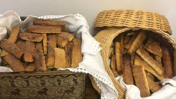 Un panier en osier et un récipient en céramique remplis de gressins.