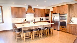 Enjoy cooking in this well-equipped kitchen with a large island and central range hood.