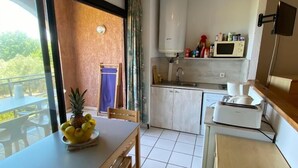 Une cuisine moderne avec un coin repas, un chauffe-eau et un téléviseur fixé au mur.