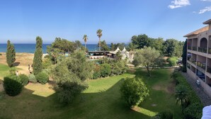 Un complexe hôtelier doté d’une piscine, d’une végétation luxuriante et offrant une vue sur la mer.