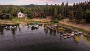 A lakeside property with docked boats, a large house, and surrounding forest. - Romantic Lakefront Studio with Private Hot Tub, Lake Views, Near the Village (Big Bear Lake)