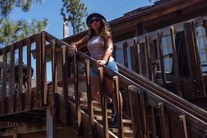 A person descending a wooden staircase with a railing. - Adorable LAKEFRONT cabin! PRIVATE HOT TUB, ROMANTIC VIEWS! (Big Bear Lake)