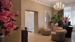 A spacious lobby with a chandelier, seating area, and floral arrangements. - Hotel Alden Splugenschloss Zurich - Leonardo Limited Edition (Zürich)