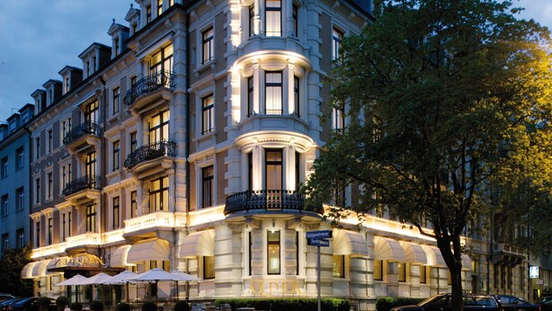 A historic building with a grand entrance, multiple balconies, and outdoor seating areas. - Hotel Alden Splugenschloss Zurich - Leonardo Limited Edition (Zürich)