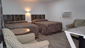 A room with two beds, a round table, and a sofa. - Lake Aire Motel (Wisconsin Dells)