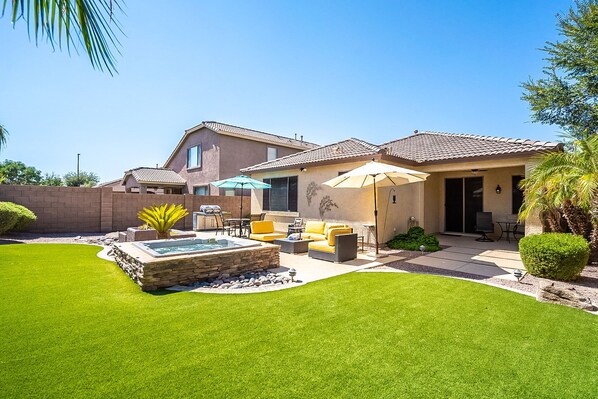 Spacious back yard with Hot tub, cozy couches, dining table and grill.