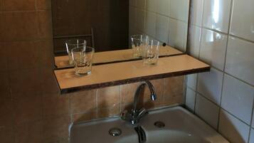 Ein Badezimmer mit Waschbecken, Spiegel und zwei Lampen.