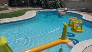 Una piscina con juguetes inflables y una red.