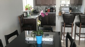 Un comedor con una mesa, sillas y una planta en maceta.