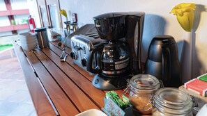 A kitchen area with a coffee maker, toaster, and various kitchen appliances on a wooden countertop.