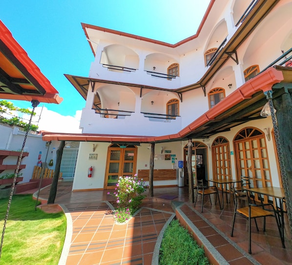 A multi-level building with a courtyard, outdoor seating area, and a fire extinguisher on the wall.