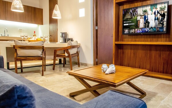 A modern living room with a wooden coffee table, a sofa, and a TV mounted on the wall.