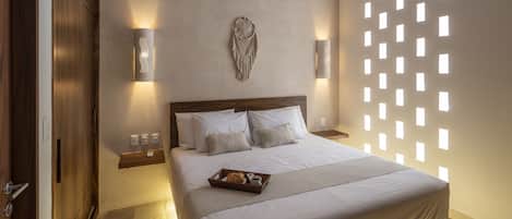 Un dormitorio moderno con una cama grande, un ventilador de techo, luces fijadas a la pared y un adorno mural.