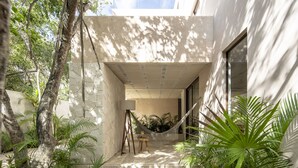 A modern outdoor patio with a hammock, a table, and lush greenery. - Kiki Tulum (Tulum)
