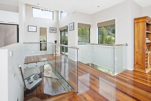 Enjoy the expansive view from the upper level, where a glass railing offers a glimpse of the outdoor area.