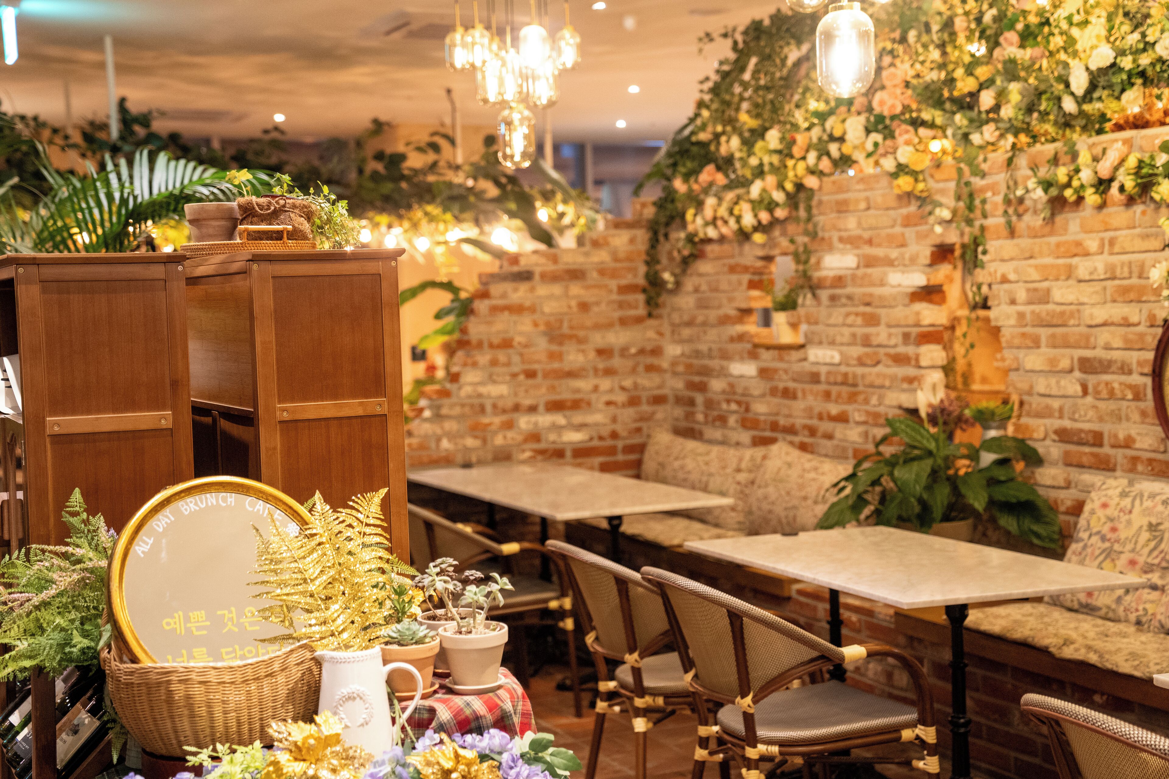 Un restaurant chaleureux avec des murs en briques, des meubles en bois et des luminaires suspendus.