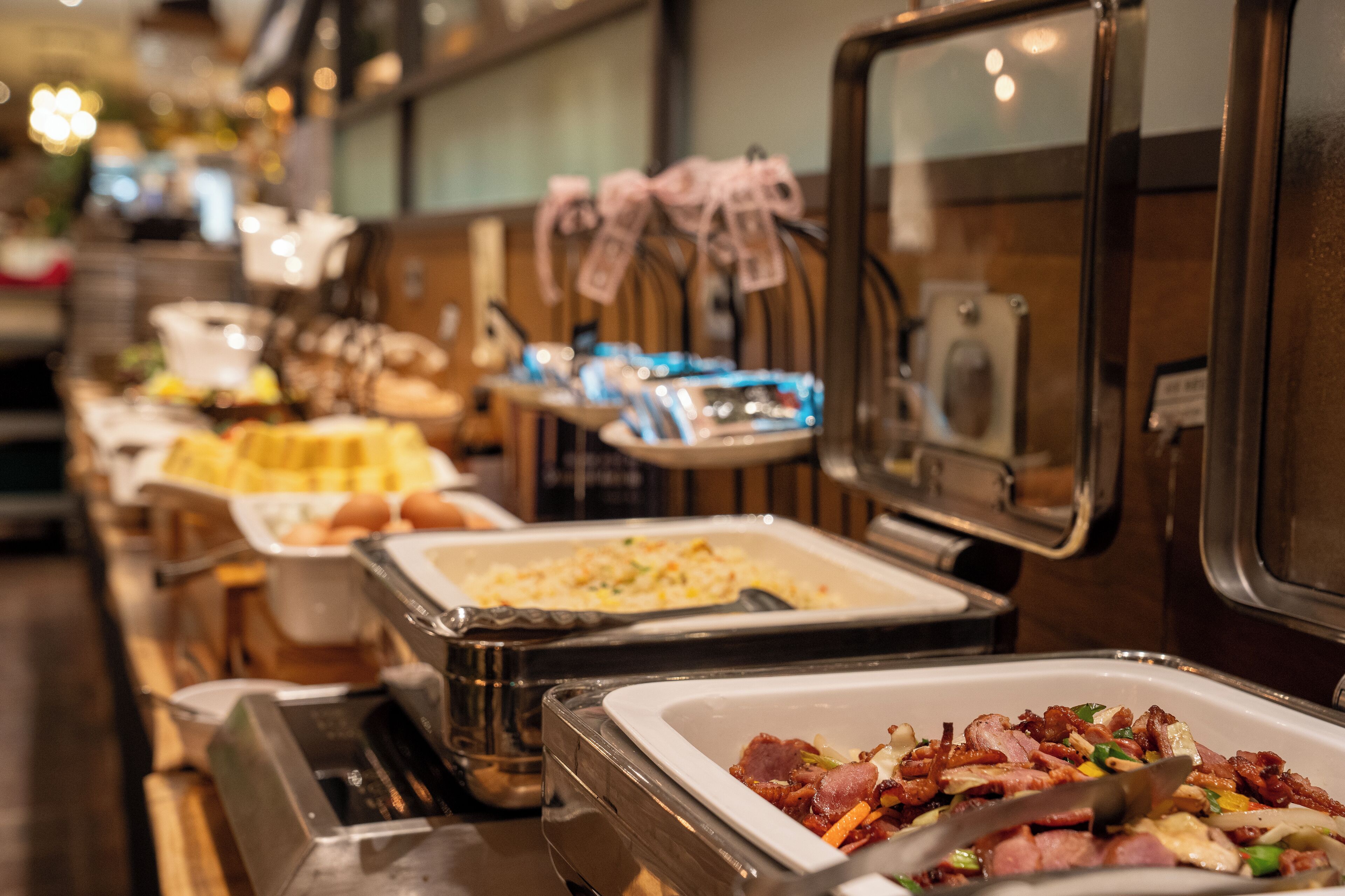 A buffet with various food options, including meats and baked goods.