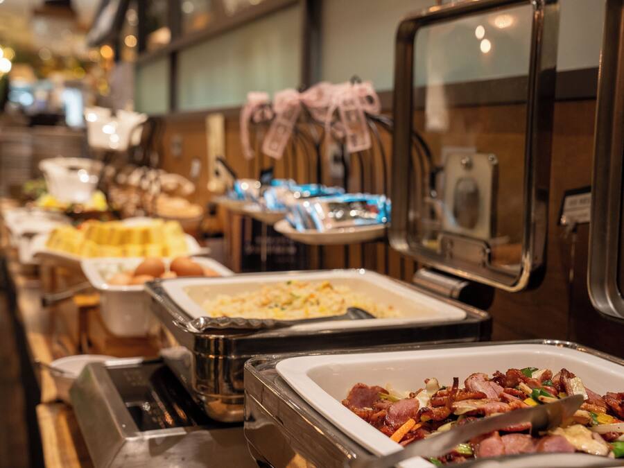 A buffet with various food options, including meats and baked goods.