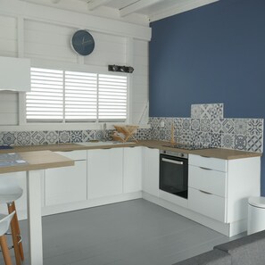 Kitchen features a sink, oven, and patterned tile backsplash.