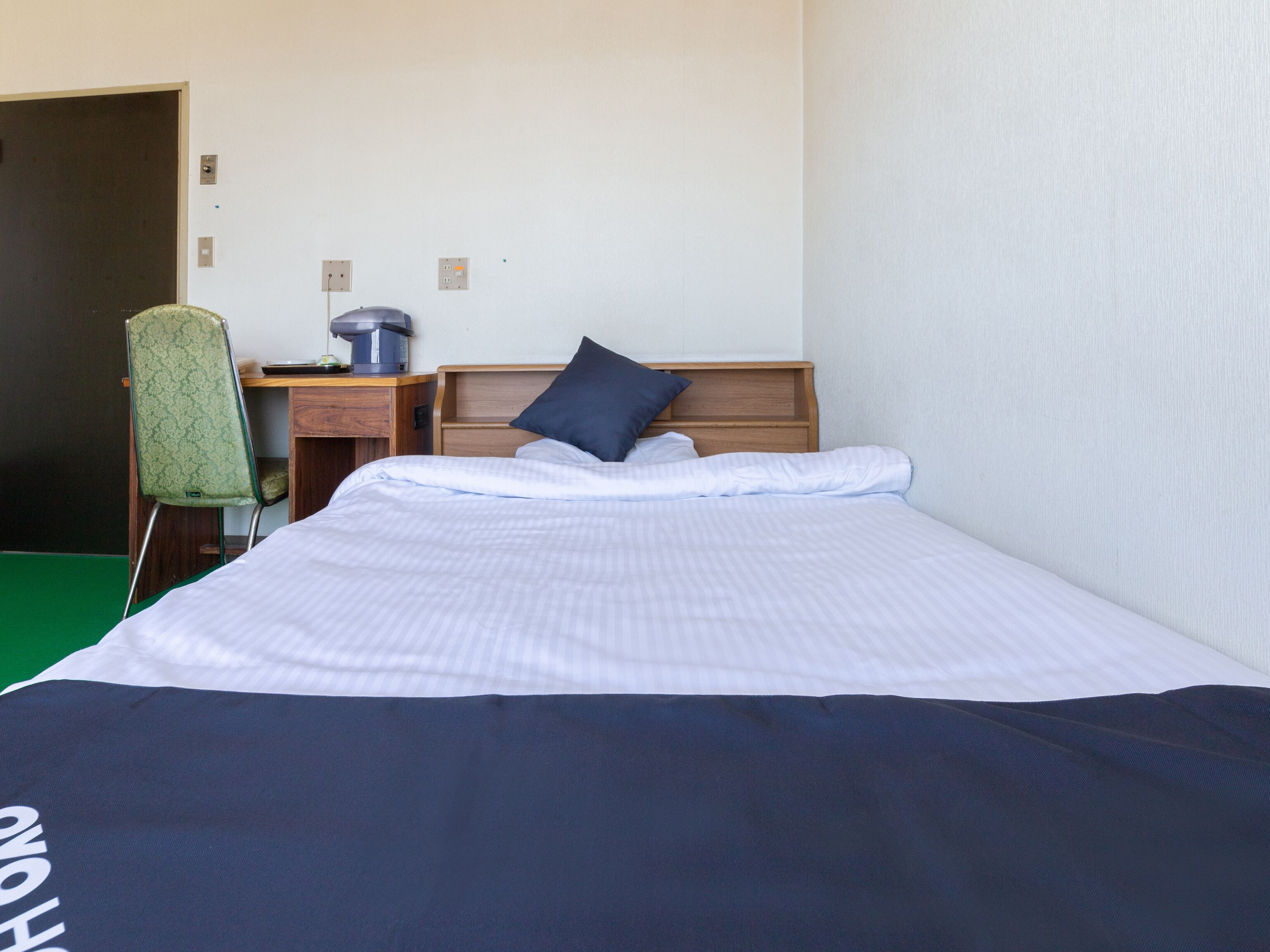 Une chambre d’hôtel avec un lit, un bureau et une chaise.
