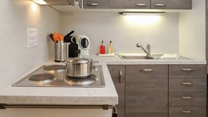 Eine moderne Küche mit Einbauherd, Spüle und Holzschränken.