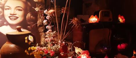 A table with a vase of flowers, a teapot, and a cup.