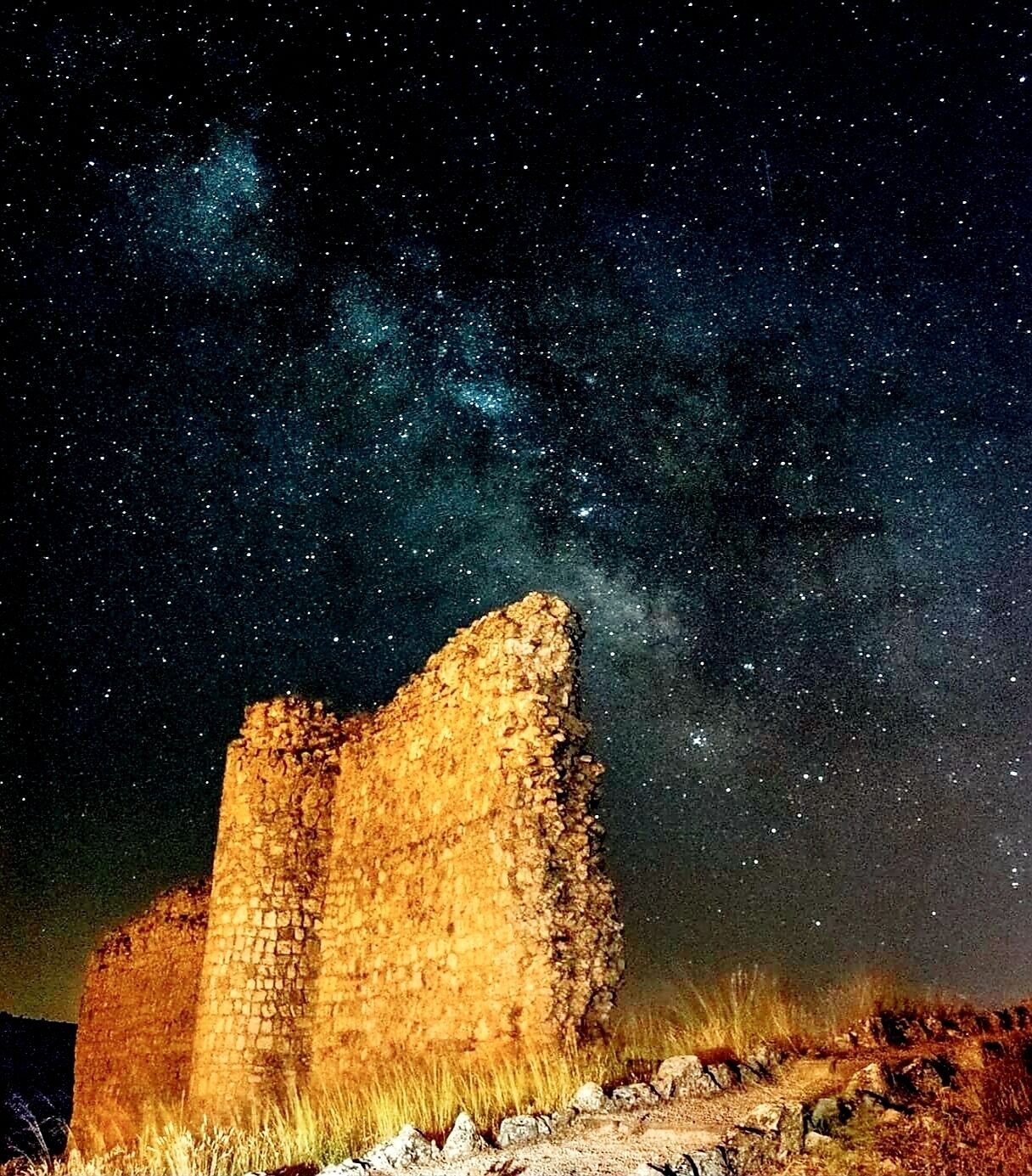 Estrutura de pedra histórica sob um céu estrelado.