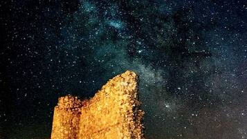 Estrutura de pedra histórica sob um céu estrelado.