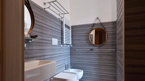 A modern bathroom with a large sink, two toilets, and a mirror. - Veneto Suite Rome (Rome)