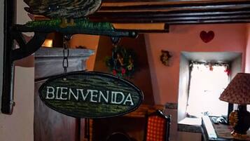 Un intérieur rustique avec un plafond en bois, une enseigne « BIENVENIDA », une décoration en forme de canard et un cœur peint sur le mur.