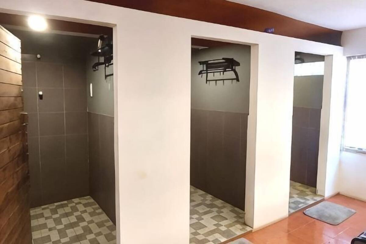A bathroom with a checkered floor, a wooden wall, and a bench.