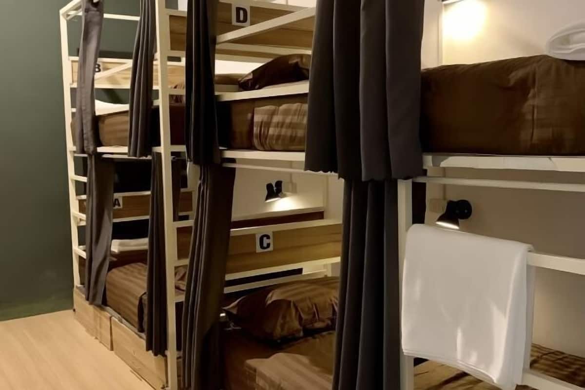 A bunk bed room with storage compartments labeled A, B, C, and D, and a bedside table with a lamp.