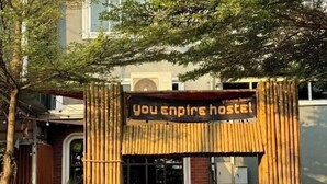 A hostel entrance with a bamboo archway and a sign that reads 'You Empire Hostel.' - You empire Hostel and Bar (Pakse)