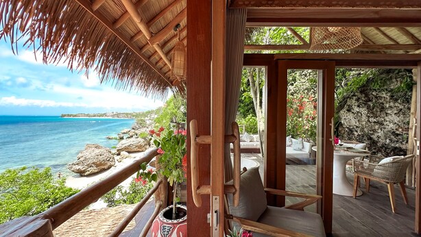 A wooden deck with a thatched roof overlooking a beach. - The Korowai (Pecatu)