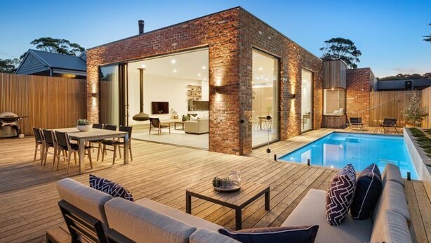 A modern house with a brick exterior, a glass door leading to a dining area, and a pool. - LUXE poolside living, in the heart of Flinders. (Flinders)
