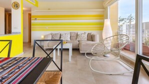 A modern living room with a sofa, a coffee table, a chair, and a large window. - Carnaval by Interhome (Isla Cristina)