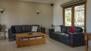 A living room with two sofas, a coffee table, and wall-mounted lamps. - 131 Your Vineyard Home in the heart of the Vale (McLaren Flat)
