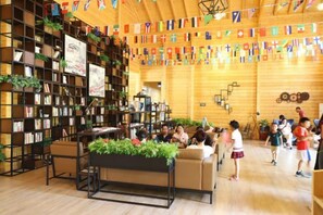 A library with bookshelves, a reading area, and a staircase. - Midea Egret Lake Car Theme Hotel (Foshan)