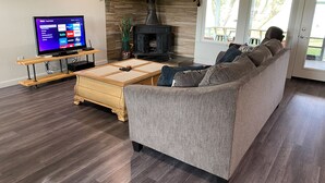 Una sala de estar con sofá, televisor, chimenea y un letrero que dice "LIVE LOVE LAKE".